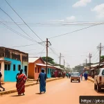 Home 20 남수단에서 집을 구하는 방법 - A vibrant street scene in Juba, South Sudan, showcasing a mix of simple traditional houses and moder...